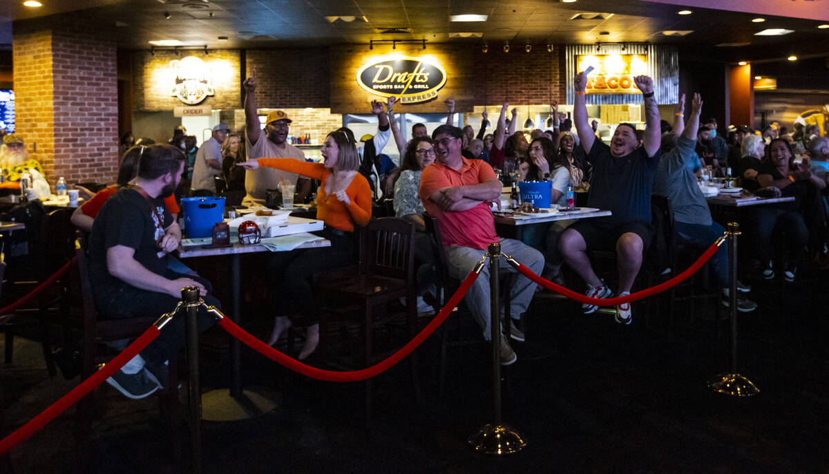 Attendees cheer after the coin toss at the start of the Super Bowl watch party at the Westgate ...