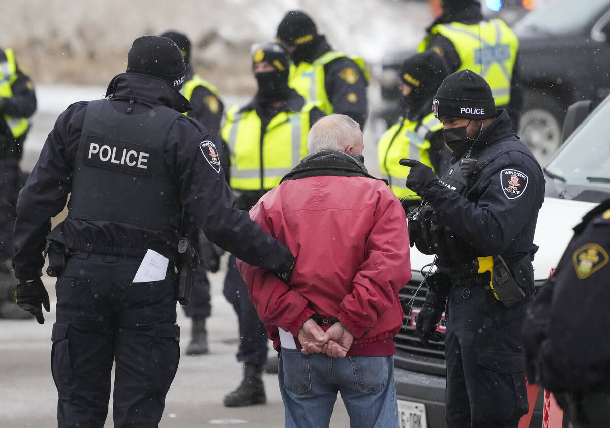 A protester is arrested by as police remove truckers and supporters after a court injunction ga ...