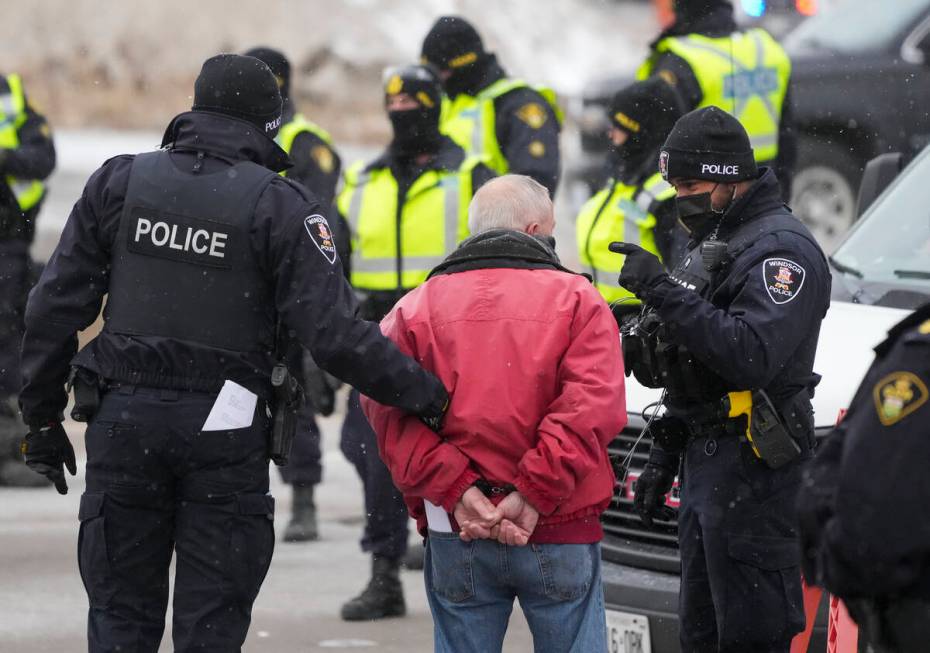 A protester is arrested by as police remove truckers and supporters after a court injunction ga ...