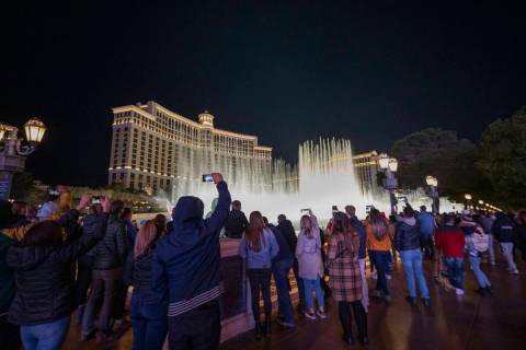 A crowd watches the Fountains at Bellagio on the Strip, Friday, Nov. 27, 2020, in Las Vegas. (E ...
