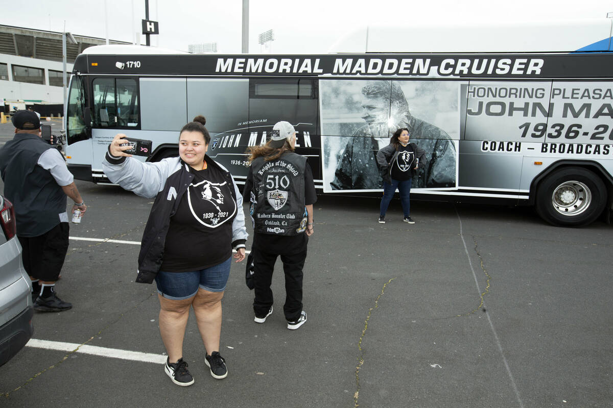 Mercedes Walker, of Oakland, Calif., takes a photo in front of a "Maddencruiser" bus ...