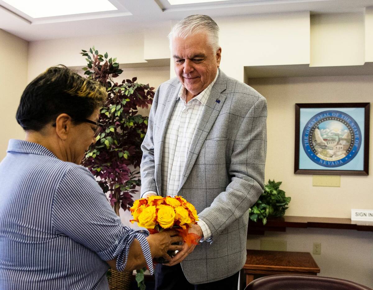 Irma Nunez, a personal care aid, receives Valentine’s Day flowers from Gov. Steve Sisolak bef ...