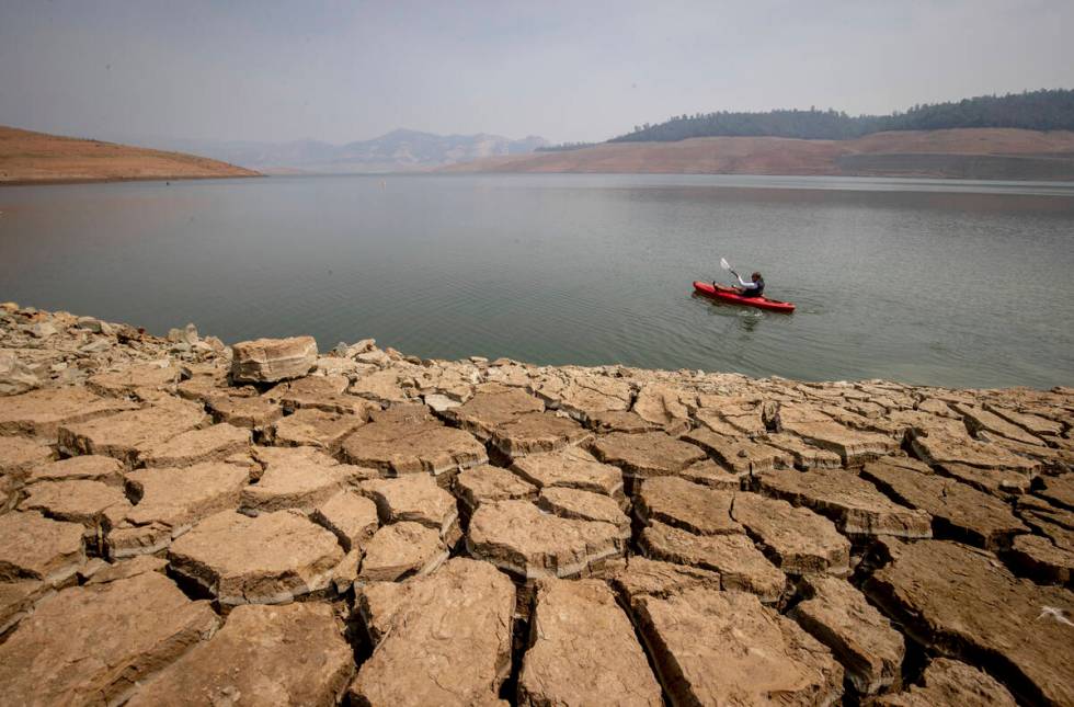 A kayaker paddles in Lake Oroville as water levels remain low due to continuing drought conditi ...