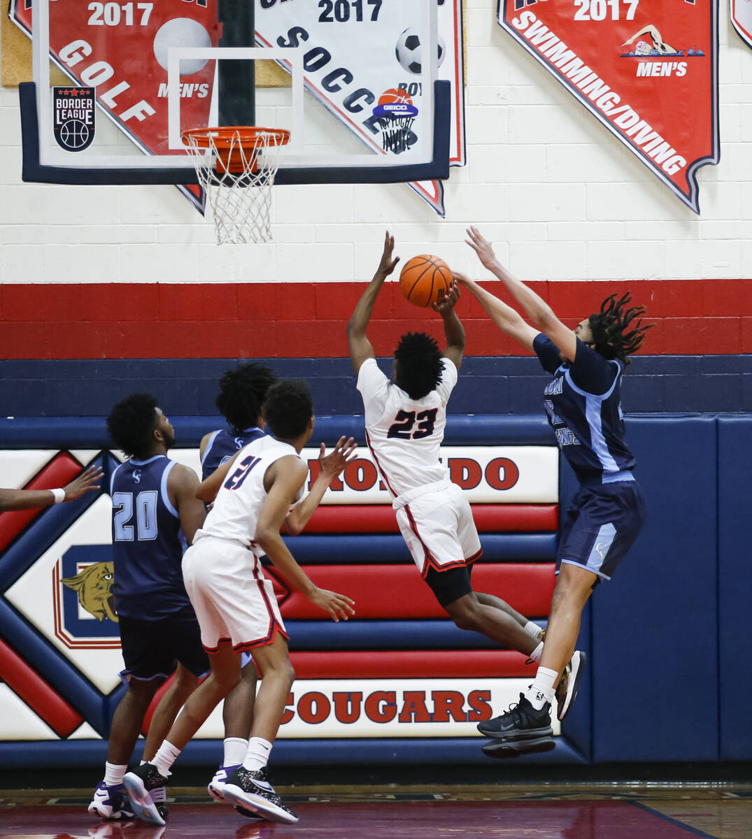 Coronado's Josiah Cunningham (23) gets fouled by Canyon Springs' Jalen Foy (15) during the seco ...