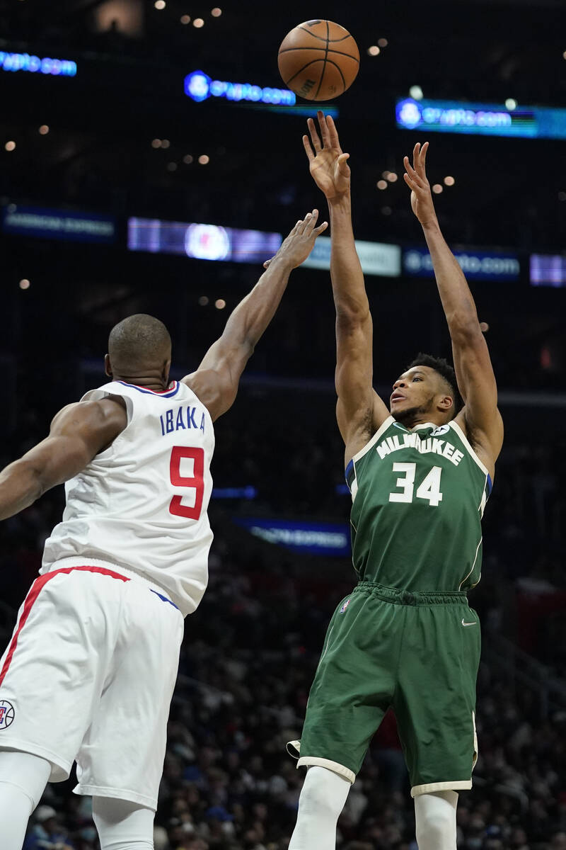 Milwaukee Bucks forward Giannis Antetokounmpo, right, shoots as Los Angeles Clippers center Ser ...