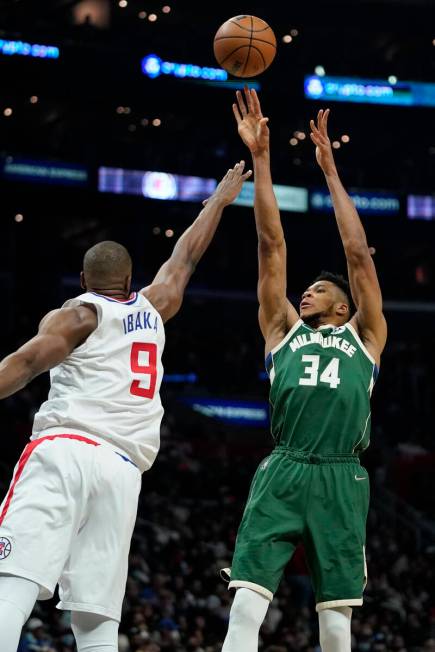 Milwaukee Bucks forward Giannis Antetokounmpo, right, shoots as Los Angeles Clippers center Ser ...
