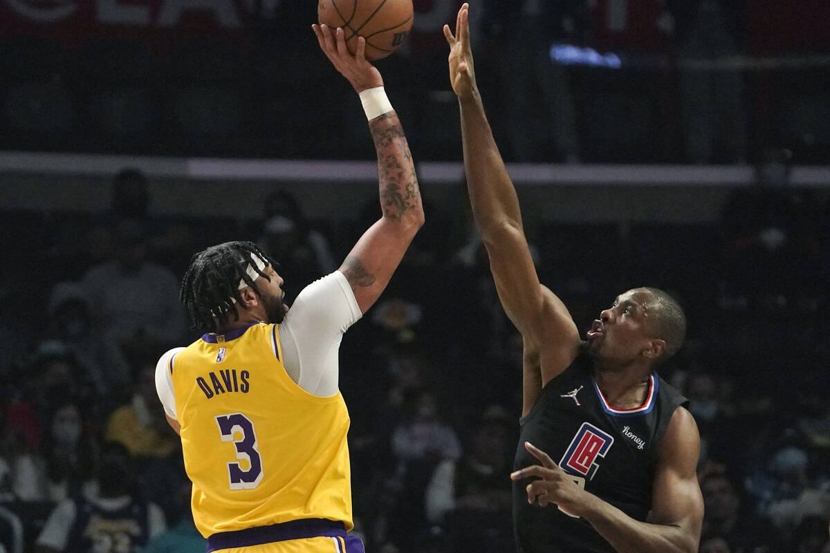 Los Angeles Lakers guard Talen Horton-Tucker, left, shoots as Los Angeles Clippers center Serge ...
