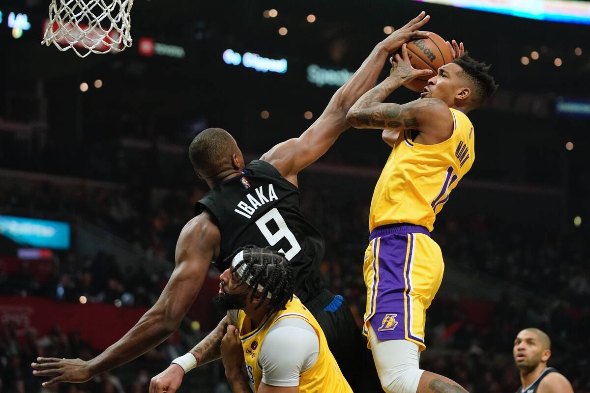 Los Angeles Lakers guard Malik Monk, right, shoots as Los Angeles Clippers center Serge Ibaka, ...