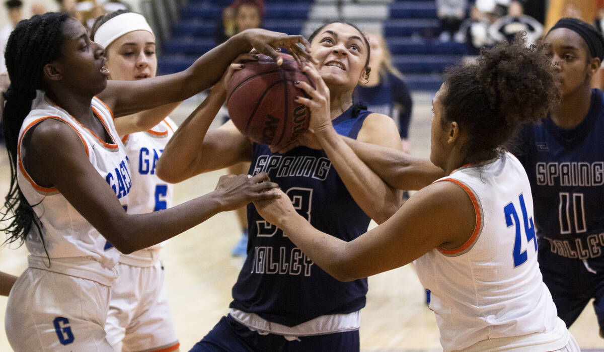 Spring Valley forward Briana Green (33) is fouled by Bishop Gorman forward Shaolin Cooper (24) ...