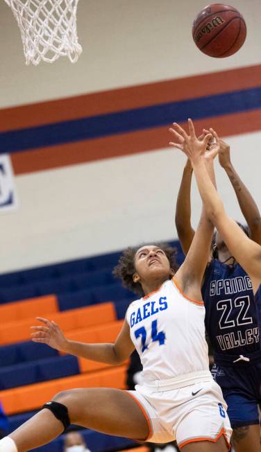 Bishop Gorman forward Shaolin Cooper (24) fights for a rebound with Spring Valley forward Rayne ...