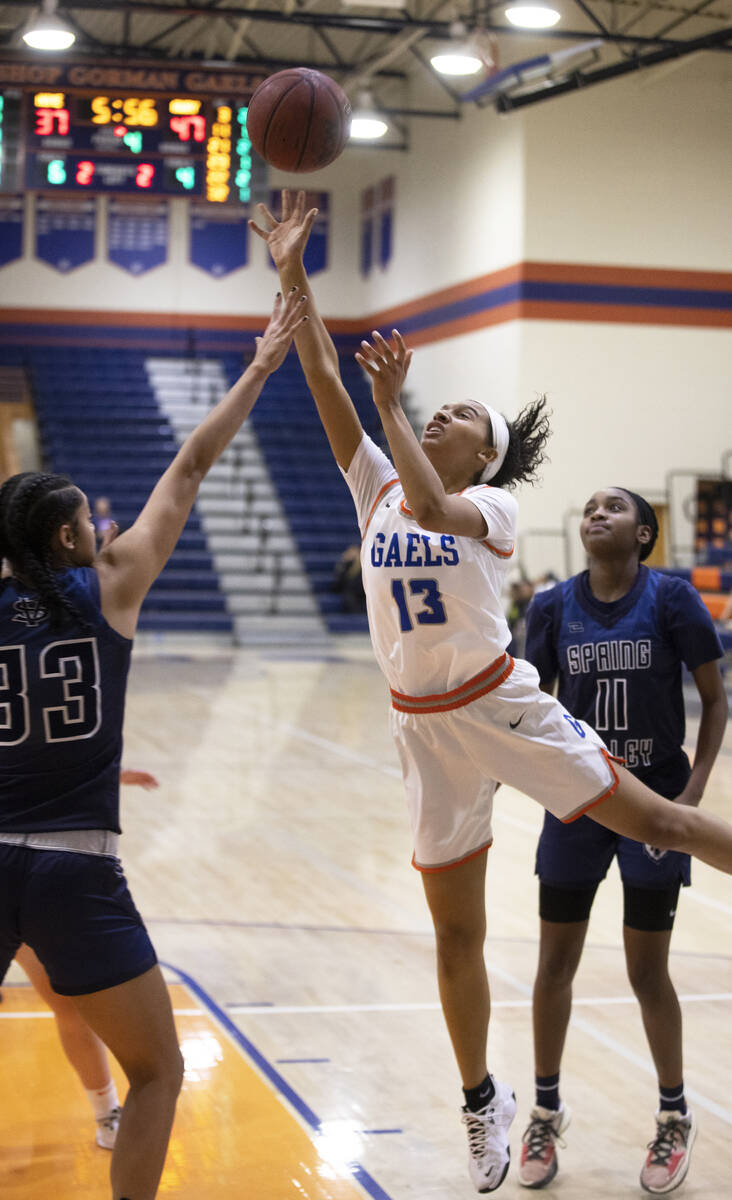 Bishop Gorman guard Reina Bell (13) drives past Spring Valley forward Briana Green (33) in the ...