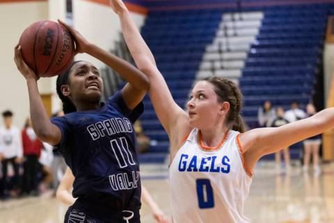Spring Valley's Jaila Childress (11) drives past Bishop Gorman guard Silvia Garcia (1) in the f ...