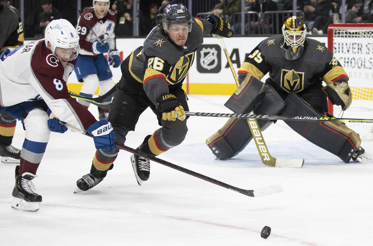 Golden Knights center Mattias Janmark (26) reaches for a loose puck against Colorado Avalanche ...