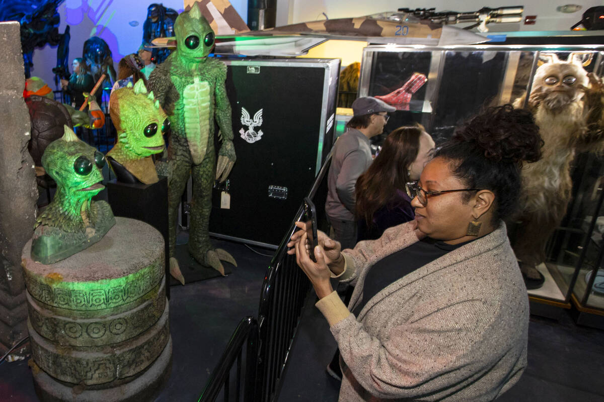 Darlene Idei, right, takes a picture during a preview of The Movie Prop Experience at Neonopoli ...