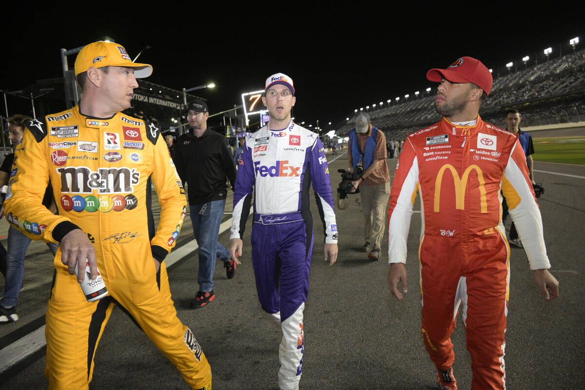 Kyle Busch, left, Denny Hamlin, center, and Bubba Wallace walk down pit road before the second ...