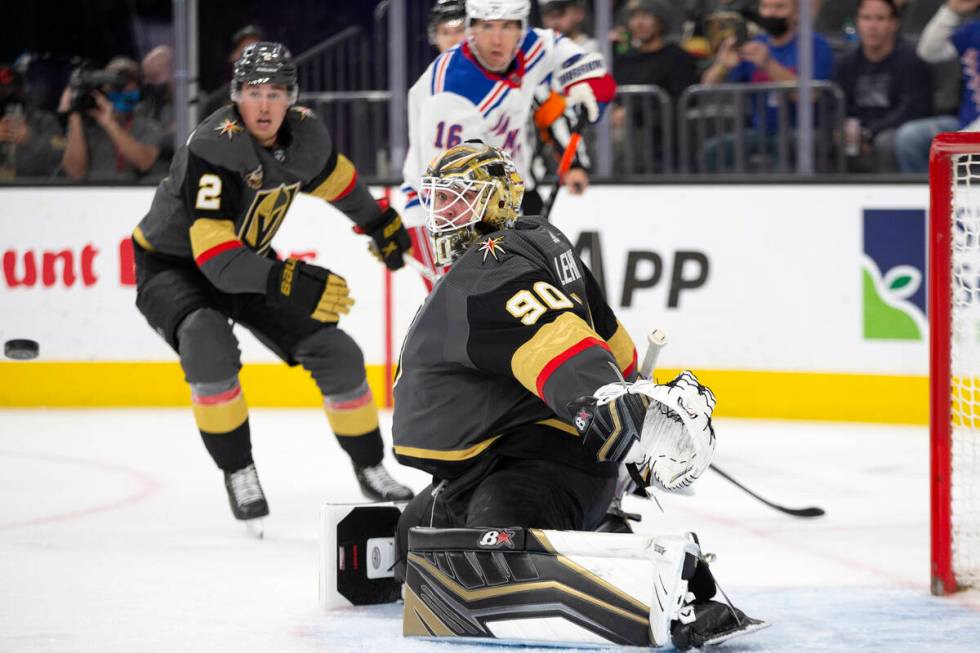 Golden Knights goaltender Robin Lehner (90) reaches to save while defenseman Zach Whitecloud (2 ...