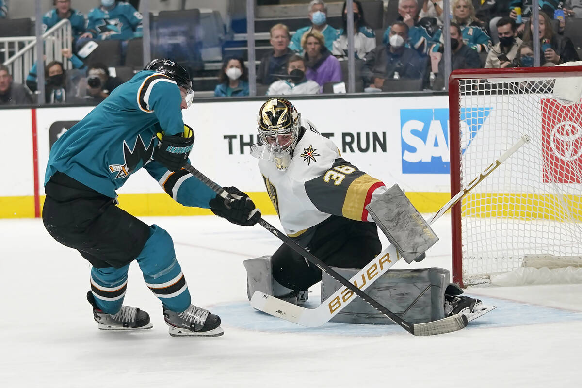 Vegas Golden Knights goaltender Logan Thompson, right, defends against a shot attempt by San Jo ...