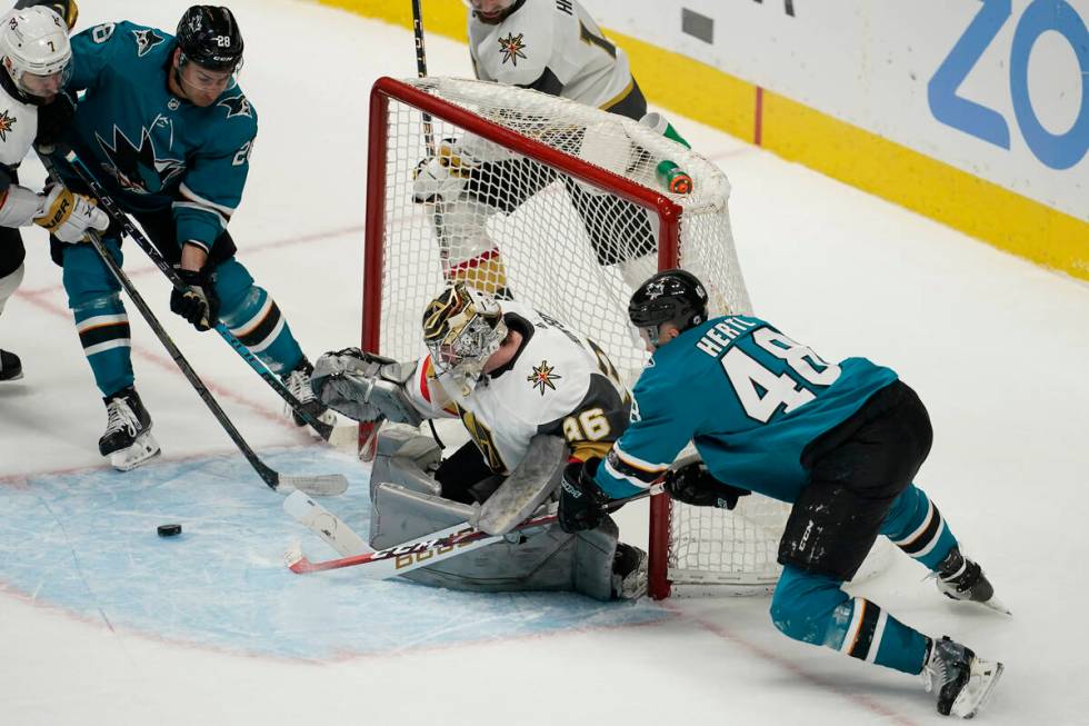 Vegas Golden Knights goaltender Logan Thompson, middle, defends the goal between San Jose Shark ...