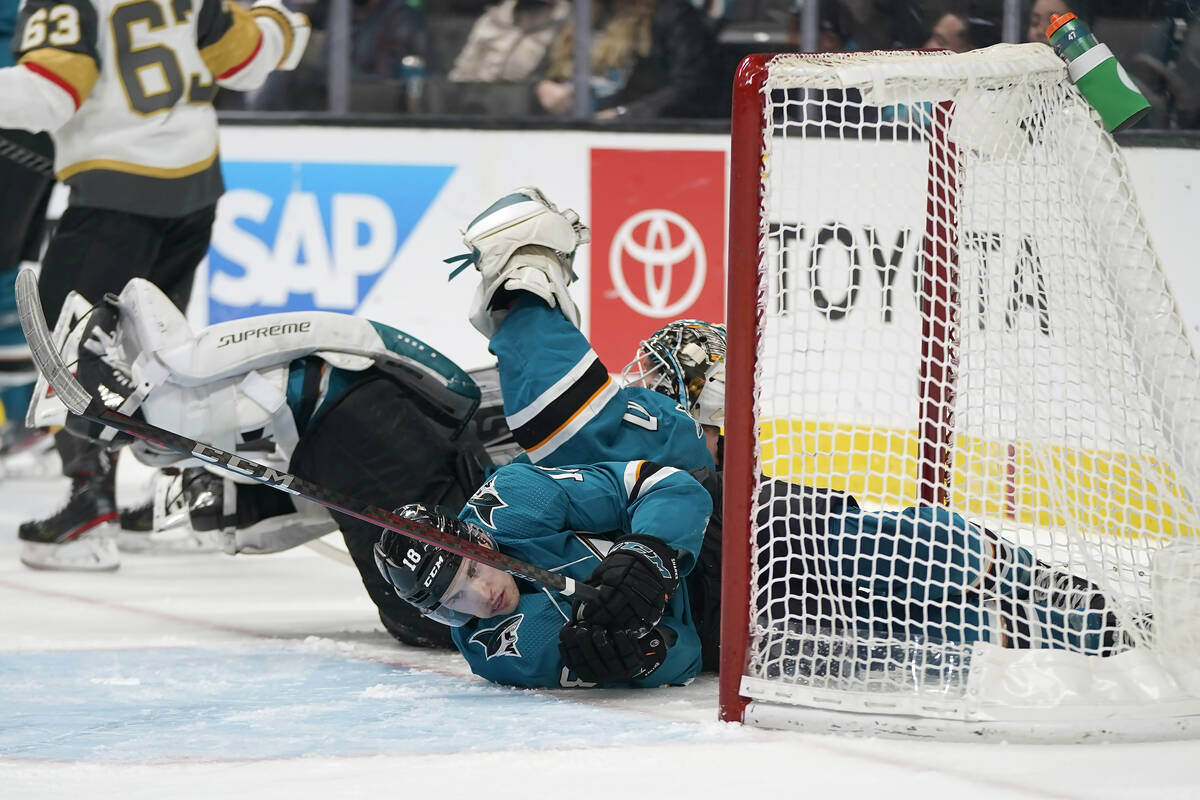 San Jose Sharks center Lane Pederson, foregound, and goaltender James Reimer crash into the net ...