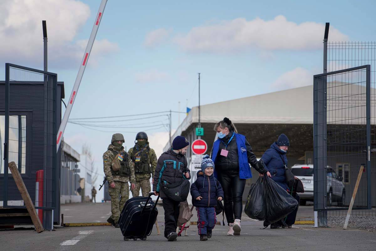 A woman with her children crosses a checkpoint from territory controlled by Russia-backed separ ...