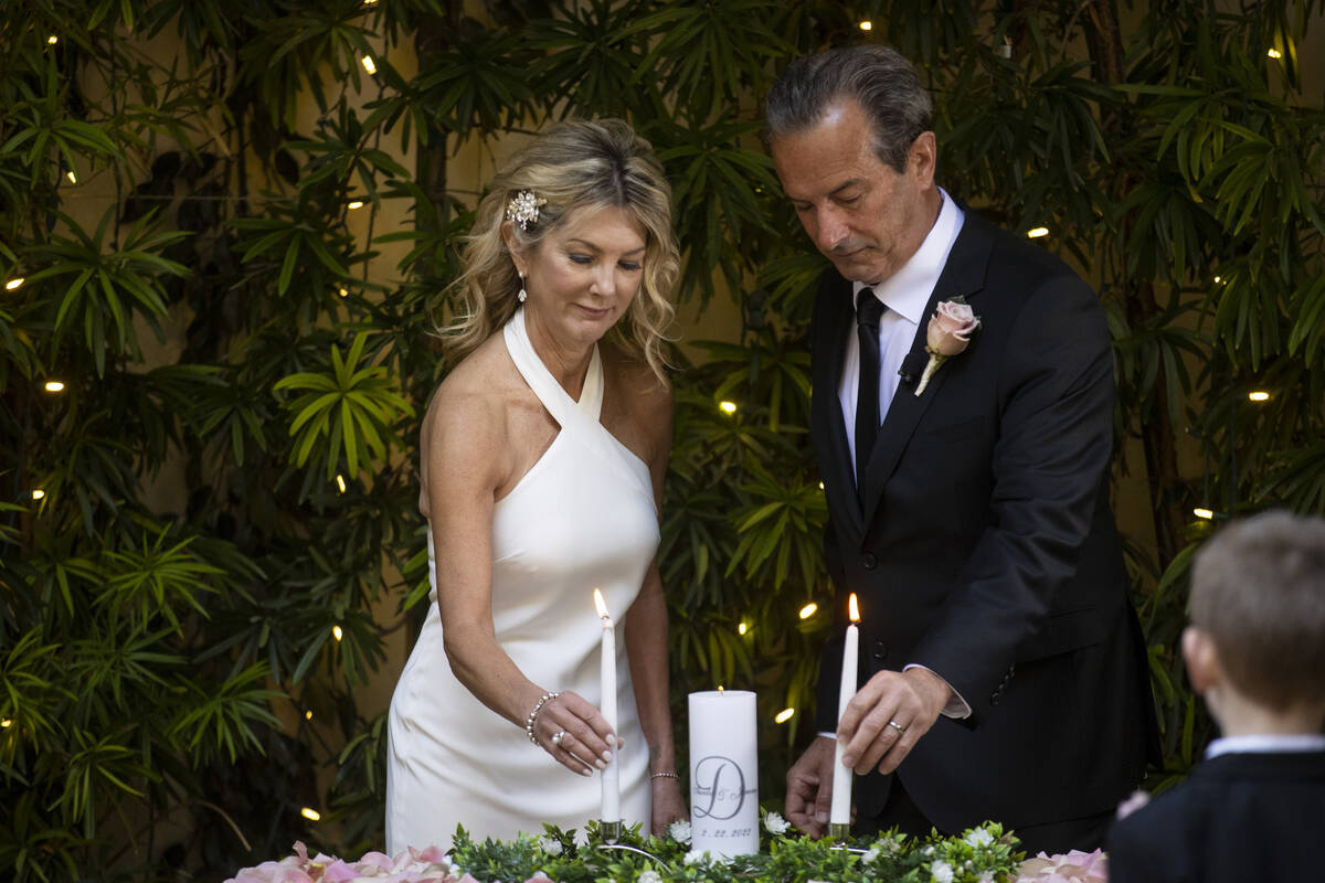 Sheila Daley, left, and James Dunbar, light up their unity candle during their wedding ceremony ...