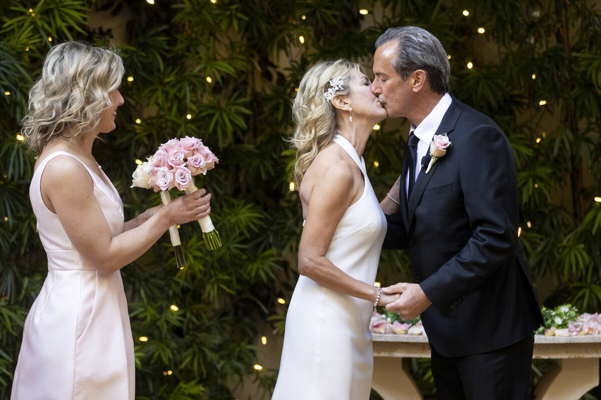 Sheila Daley, left, and James Dunbar, share a kiss during their wedding ceremony at the Wynn ho ...