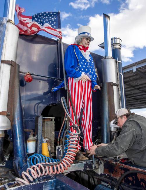 Truck driver Fred with Bouie River Trucking of Hattiesburg, Mississippi, attaches an Uncle Sam ...