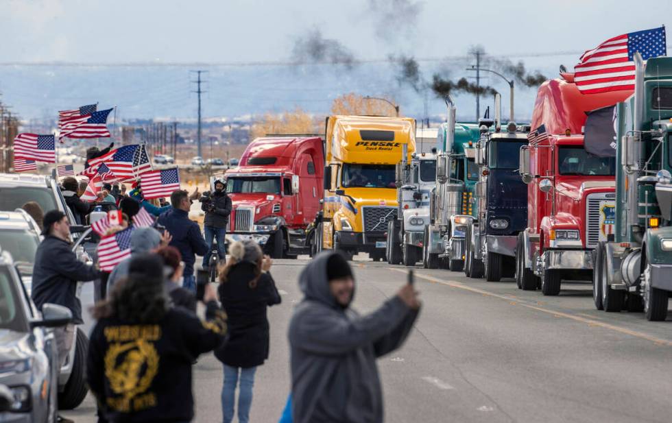 Supporters wave flags and cheer for truckers departing from a send-off event for The People&#x2 ...