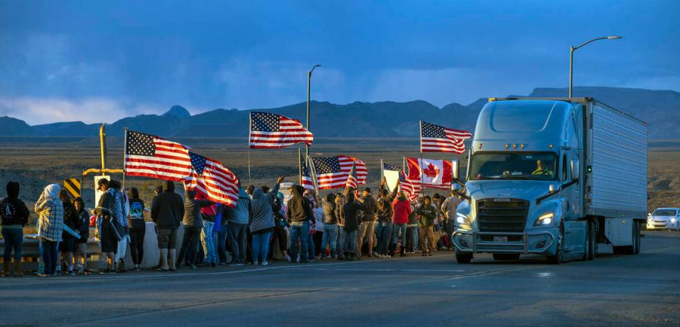 Supporters line an I-40 overpass at sunset in Arizona nearly 20 miles out of Kingman awaiting T ...