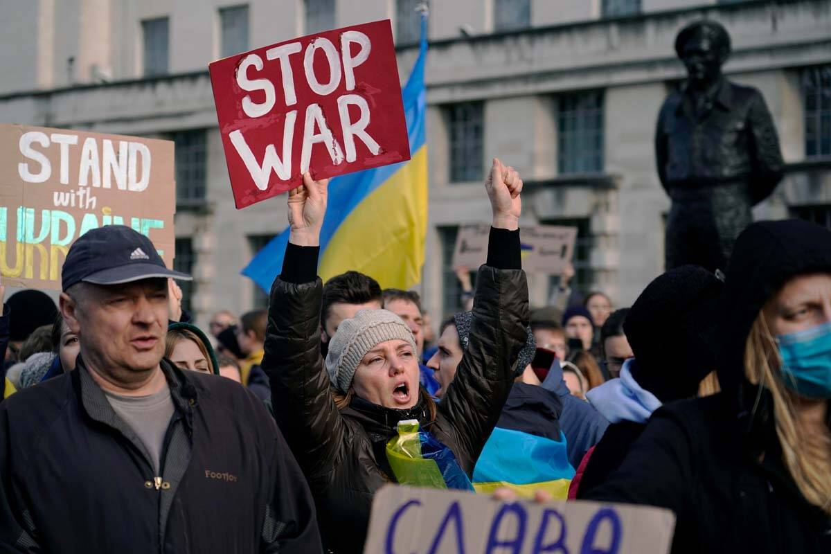 A demonstrator shouts slogans while holding a placard as she attends a demonstration outside Do ...