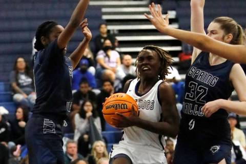Centennial High School's Mary McMorris (4), center, goes to the basket as Spring Valley High Sc ...