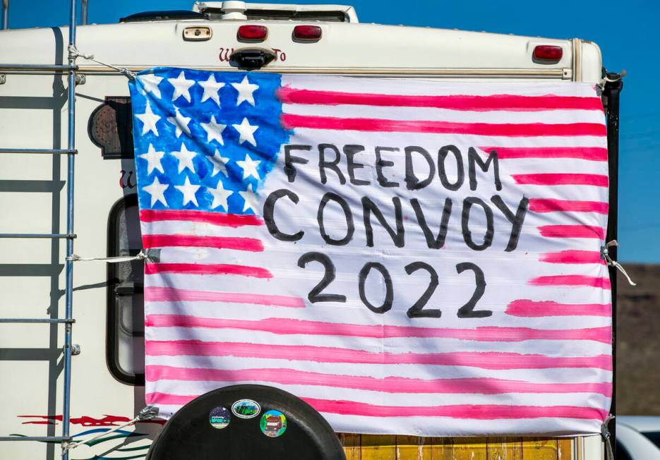 A sign hangs on the back of an RV apart of The People’s Convoy fueling up at Crazy Freds ...
