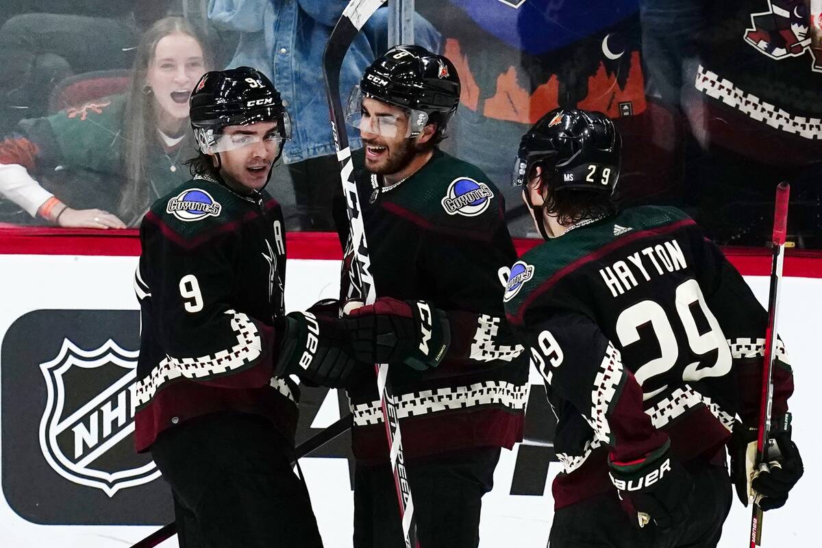 Arizona Coyotes center Nick Schmaltz, middle, smiles as he celebrates his goal against the Vega ...