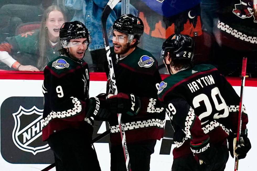 Arizona Coyotes center Nick Schmaltz, middle, smiles as he celebrates his goal against the Vega ...