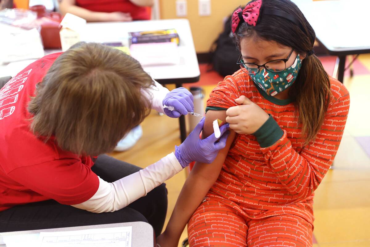 Skylar Salmo, 9, gets a COVID-19 vaccination from Susan Pruitt during a free pop-up "vaccinatio ...