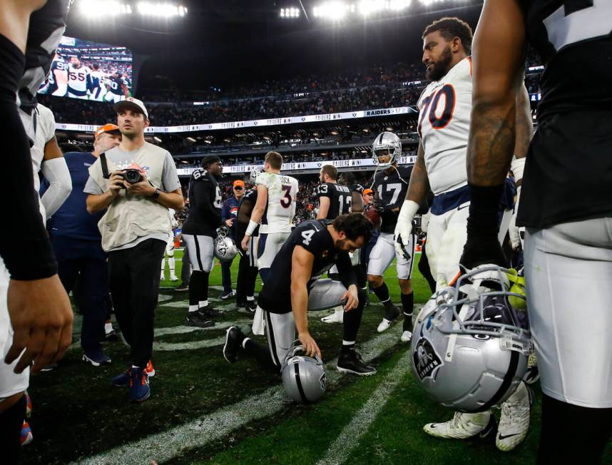 Raiders quarterback Derek Carr (4) kneels after defeating the Denver Broncos in an NFL football ...