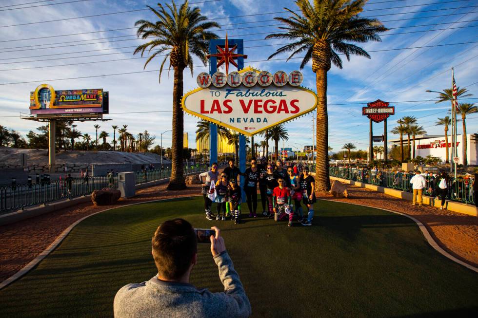 Participants stop for a photo at the “Welcome to Fabulous Las Vegas” sign during ...