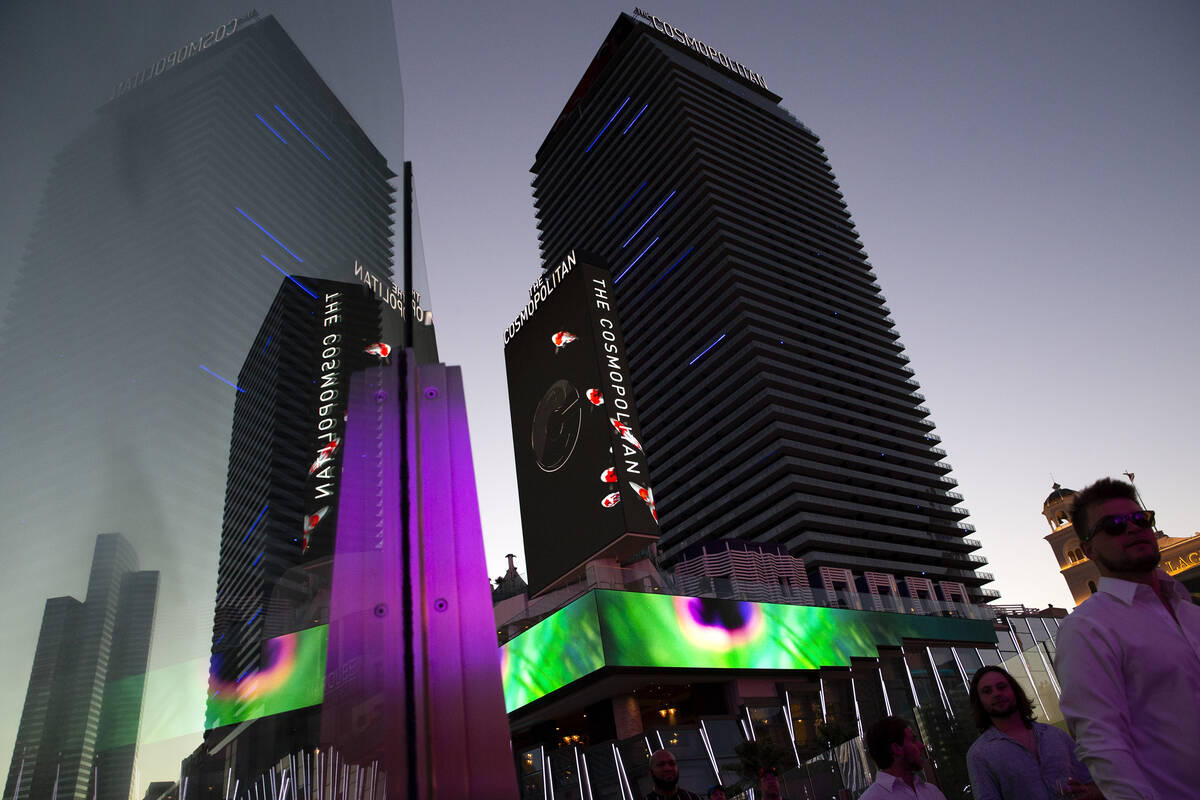 The Cosmopolitan of Las Vegas is reflected in the glass of a pedestrian bridge on Wednesday, Ju ...