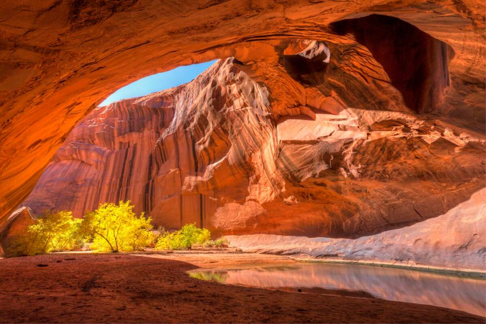 The red sandstone domed ceiling of Golden Cathedral in Neon Canyon has two arch potholes, with ...