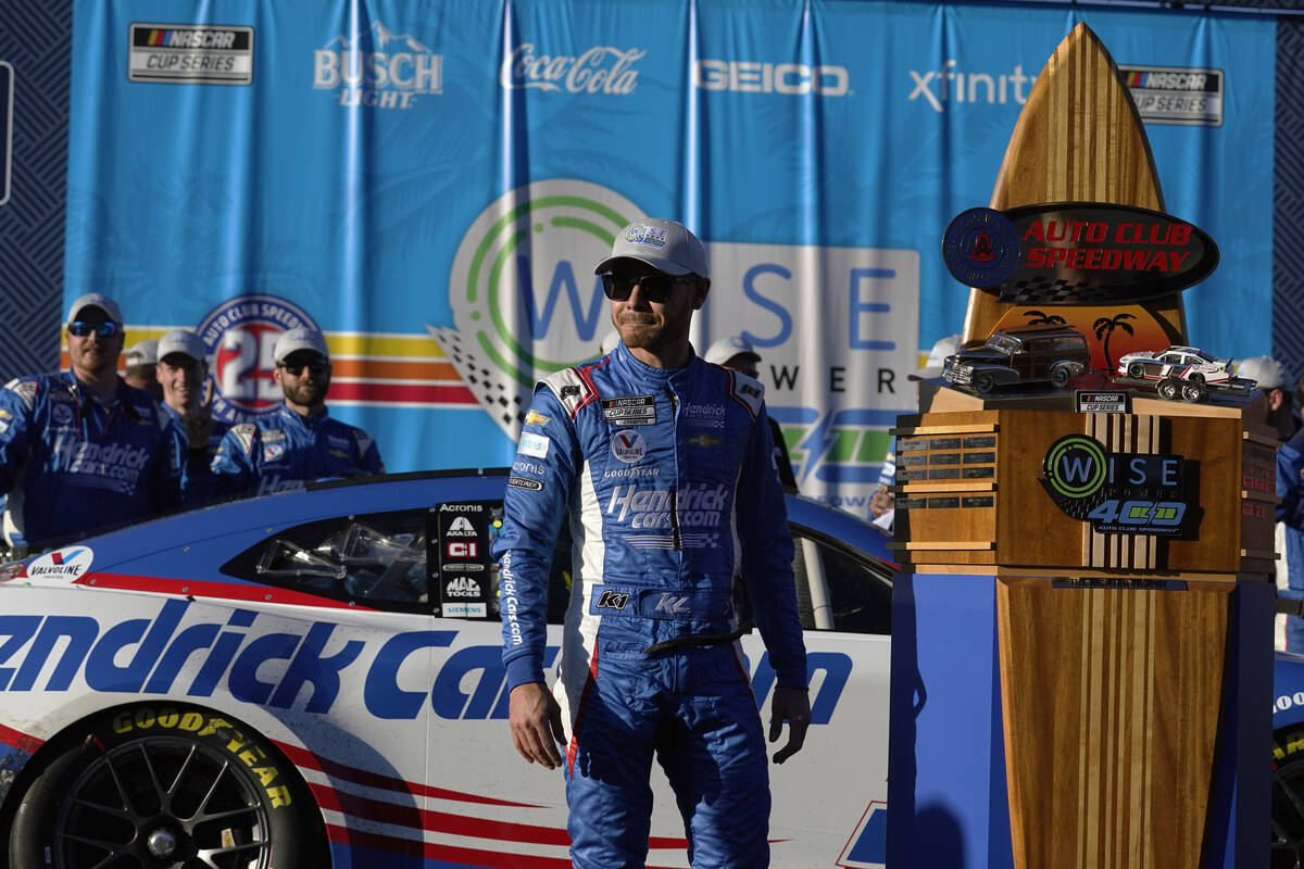 Kyle Larson stands under the podium after winning the NASCAR Cup Series auto race at Auto Club ...