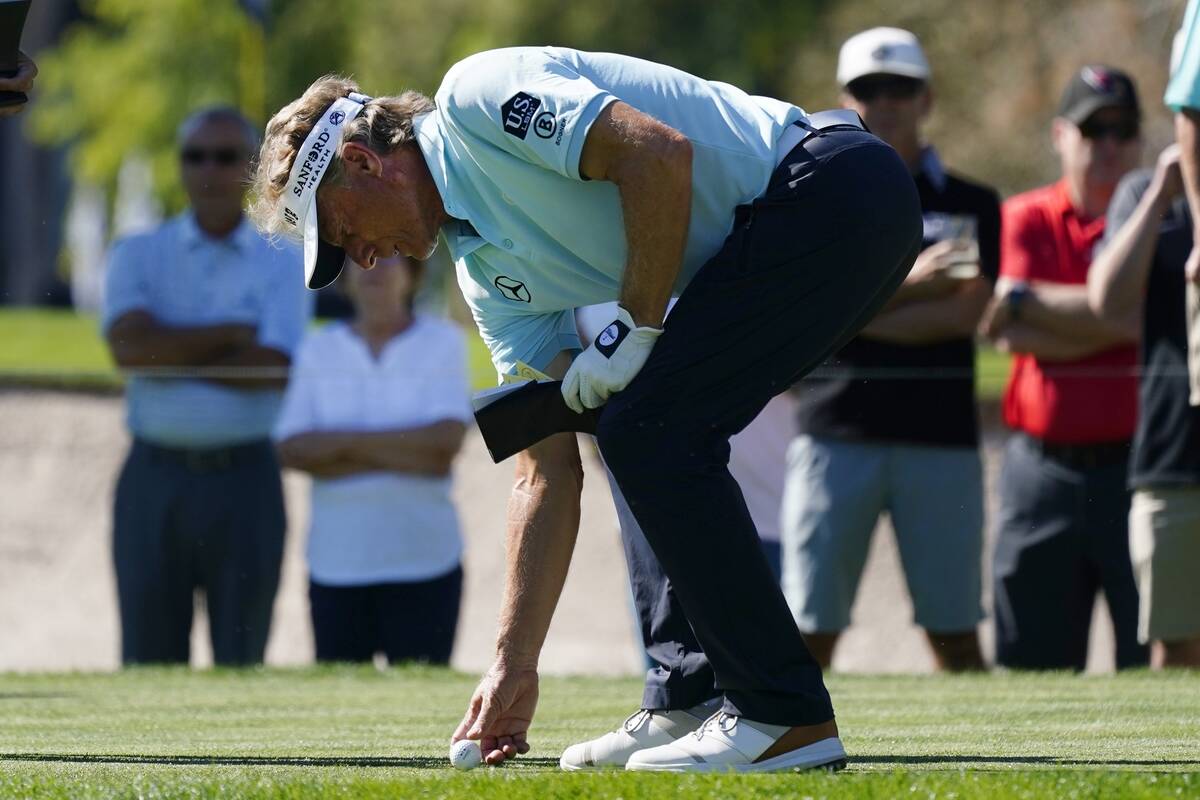 Bernhard Langer, of Germany, sets his ball at the tee box at the eighth hole during the third r ...