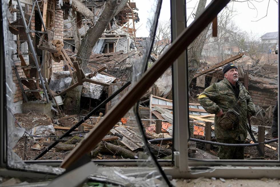 Andrey Goncharuk, 68, a member of the territorial defense stands in the backyard of a house dam ...