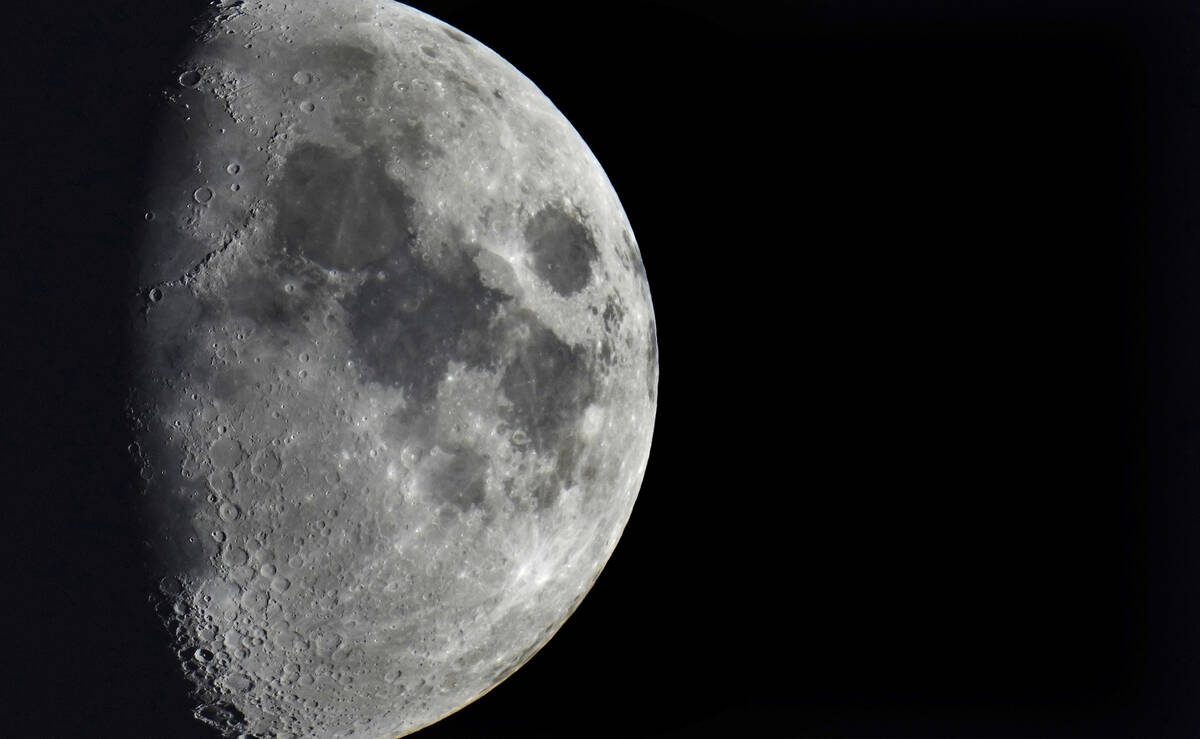 Impact craters cover the surface of the moon, seen from Berlin, Germany, Tuesday, Jan. 11, 2022 ...