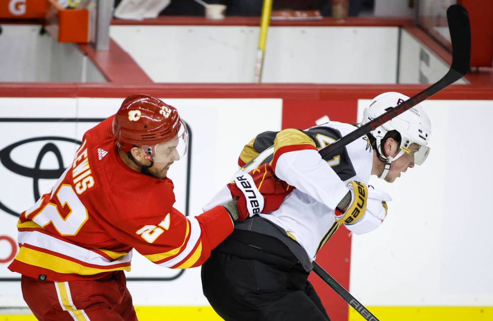 Vegas Golden Knights' Nolan Patrick, right, is hooked by Calgary Flames' Trevor Lewis during th ...