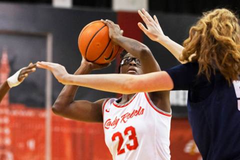 UNLV Lady Rebels center Desi-Rae Young (23) shoots over Nevada Wolf Pack forward Natalie Lathro ...