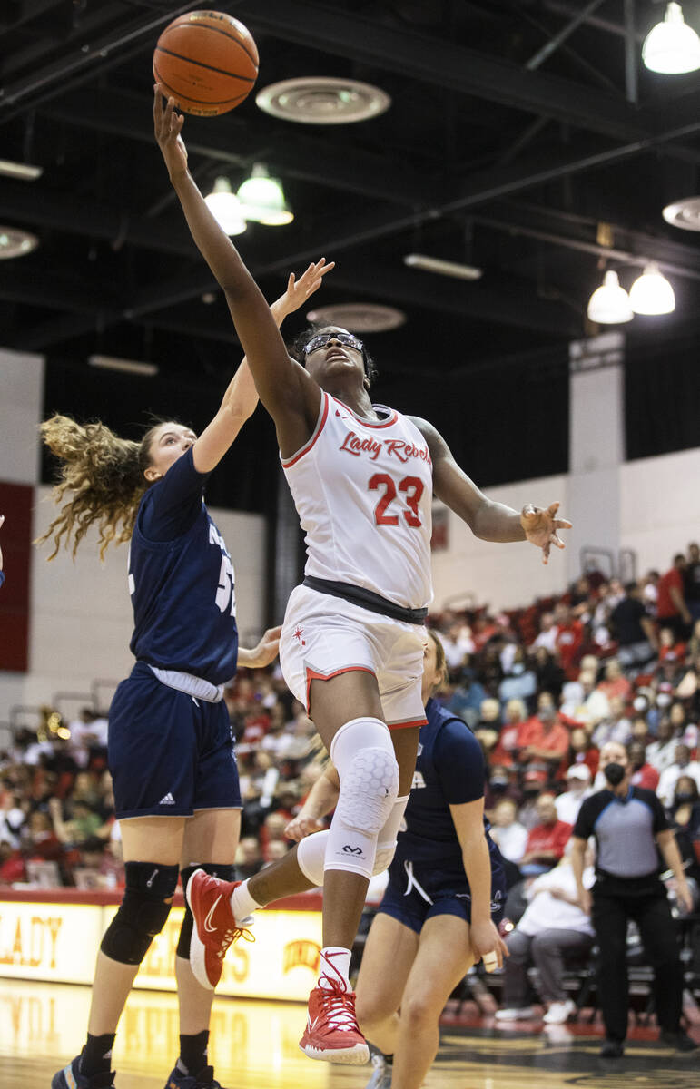 UNLV Lady Rebels center Desi-Rae Young (23) drives past Nevada Wolf Pack forward Natalie Lathro ...