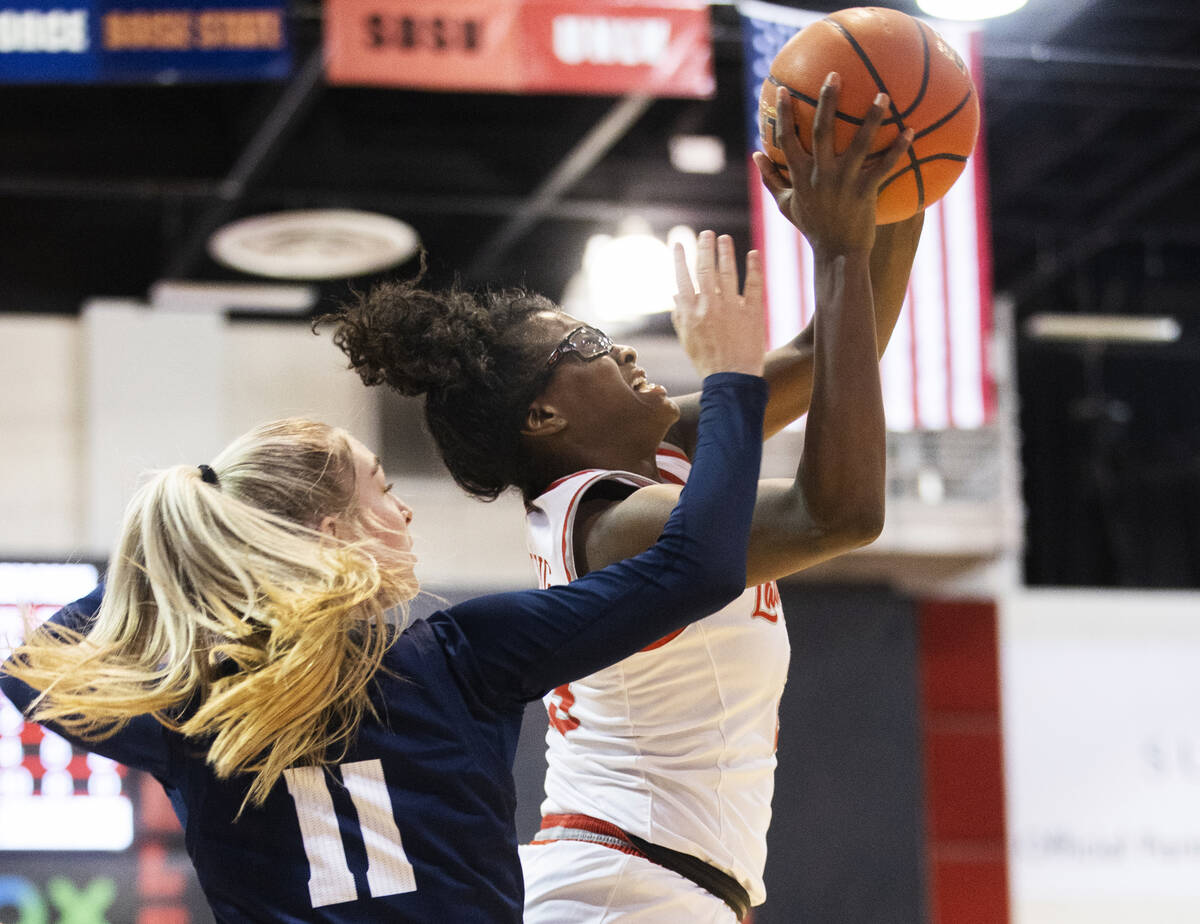 UNLV Lady Rebels center Desi-Rae Young (23) drives past Nevada Wolf Pack guard Kenna Holt (11) ...
