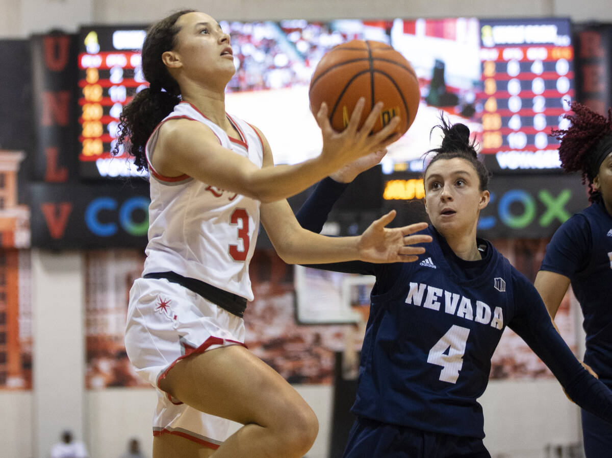 UNLV Lady Rebels guard Kiara Jackson (3) drives past Nevada Wolf Pack guard Audrey Roden (4) in ...