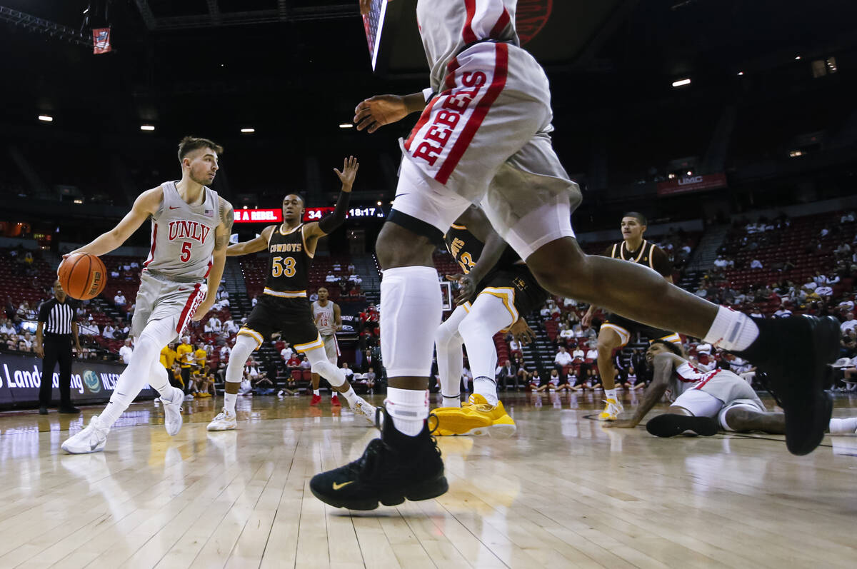 UNLV Rebels guard Jordan McCabe (5) moves the ball in front of Wyoming Cowboys guard Xavier DuS ...