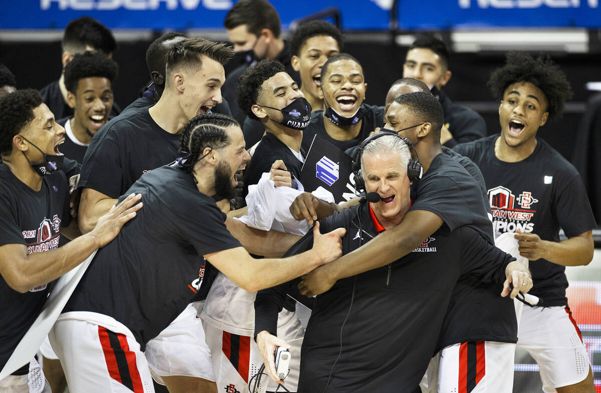 San Diego State Aztec players celebrate with San Diego State Aztecs head coach Brian Dutcher, r ...